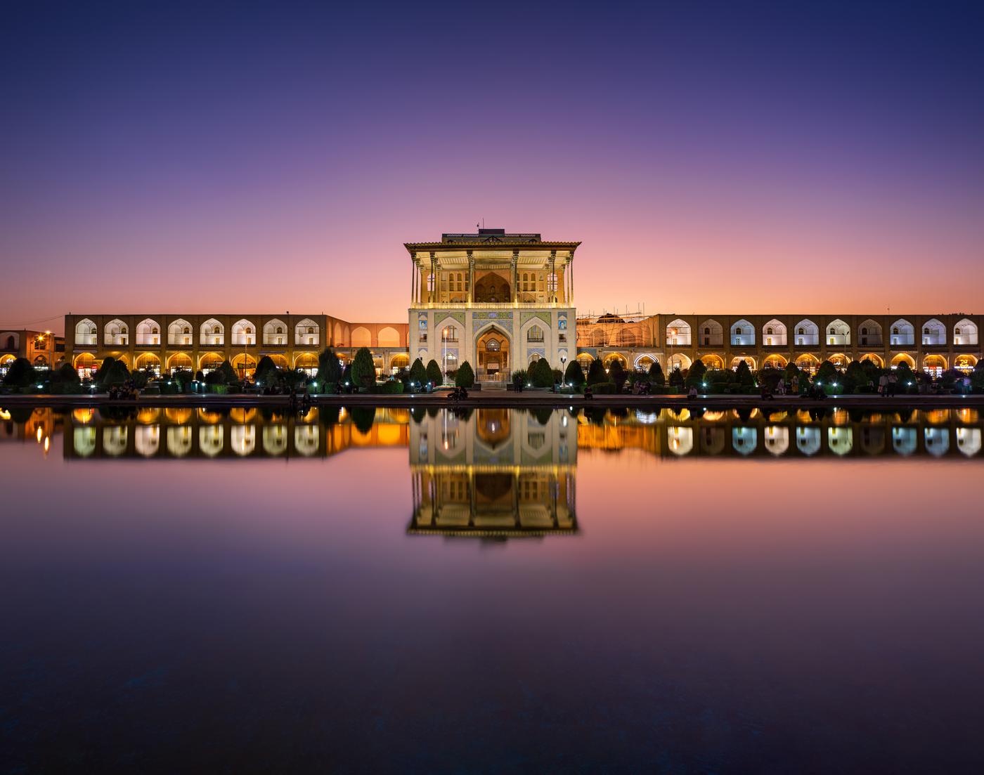 Palacio Ālī Qāpū en Isfahán al atardecer reflejado en el estanque